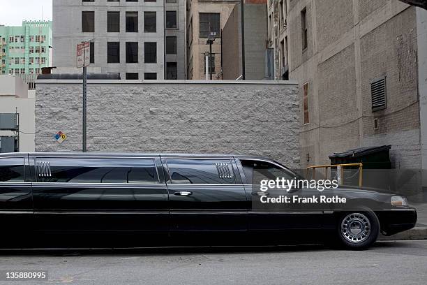 a stretch limo parks downtown - limousine stock pictures, royalty-free photos & images