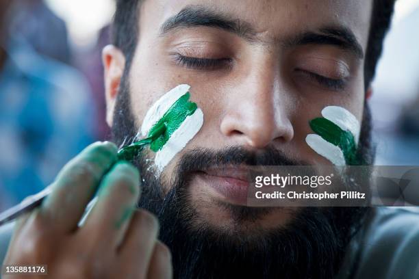 Pakistan fans having face paint applied before the start of the 2011 Cricket world cup between Pakistan vs West Indies, Lahore.