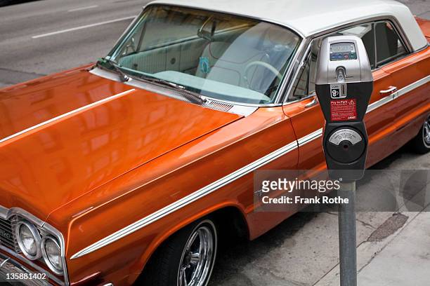 a vintage car parks near the parking meter - パーキングメータ�ー ストックフォトと画像