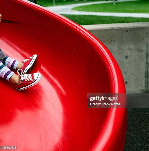 young kid gliding down a shute - red shoe stock pictures, royalty-free photos & images