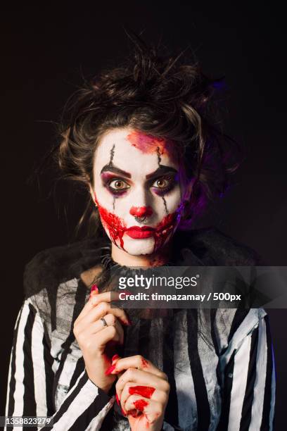 woman with scary halloween makeup and red balloon striped blouse,brazil - scary clown makeup stock-fotos und bilder