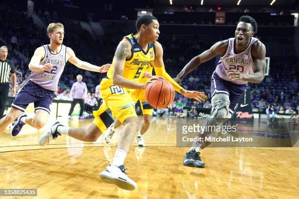 Greg Elliott of the Marquette Golden Eagles dribbles the ball during a college basketball game against the Kansas State Wildcats at the Bramlage...