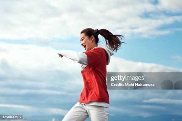 a person who dances against the blue sky. - femme ciel photos et images de collection