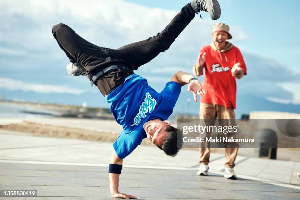 a person who dances against the blue sky. - breakdancing stock pictures, royalty-free photos & images