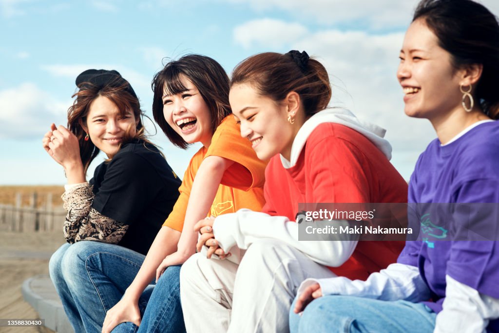 Young women talking with a smile under the blue sky.