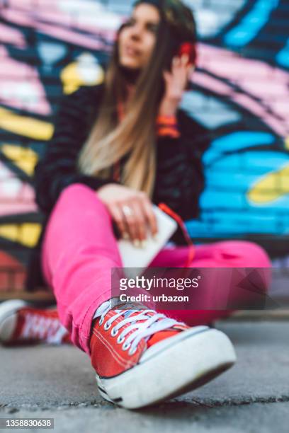 young urban woman listening to music - graffiti hintergrund stock pictures, royalty-free photos & images