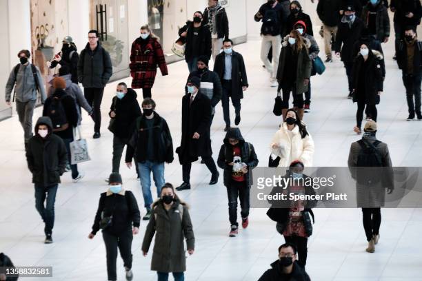 People wear masks at an indoor mall in The Oculus in lower Manhattan on the day that a mask mandate went into effect in New York on December 13, 2021...