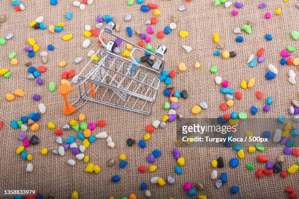pocket watch amid colorful pebbles,high angle view of multi colored shopping cart on burlap - shoppers drug mart corporation stock pictures, royalty-free photos & images