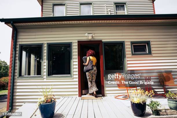 young woman returning home after yoga class - woman entering home stock-fotos und bilder