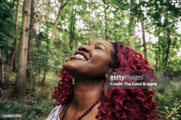 close up profile shot of young woman looking up smiling on dirt path - woman gratitude stock pictures, royalty-free photos & images