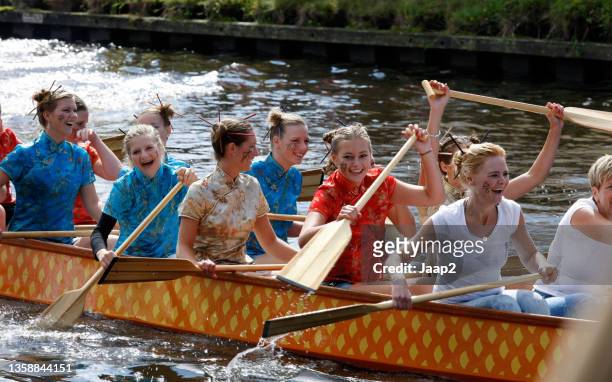 amateur team of women dressed in japanese costume in a dragon boat - dragon boat stock pictures, royalty-free photos & images