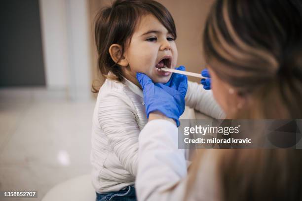 pediatrician's office - girl tongue doctor stockfoto's en -beelden