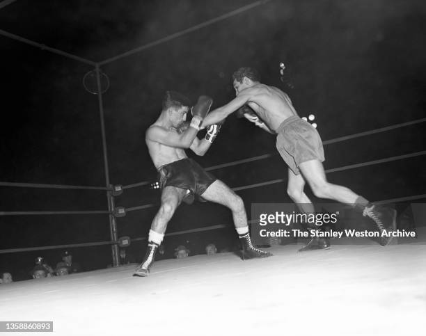 Willie Pep delivers a jab to the chin of Eddie "Compo" Campagnuolo, during their World Featherweight Title bout at Municipal Stadium, Waterbury,...