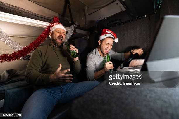 two drunk truck drivers sitting in cabin and singing on new year's eve - christmas truck stock pictures, royalty-free photos & images