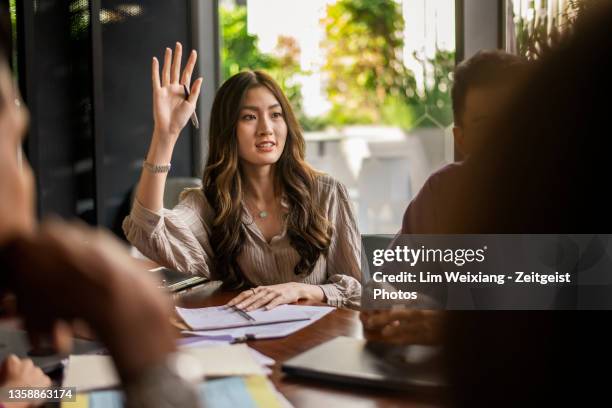 femme d’affaires posant une question lors d’une discussion - appealing photos et images de collection