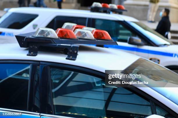 police vehicles with overhead strobe lights at a crime scene - voiture de police photos et images de collection