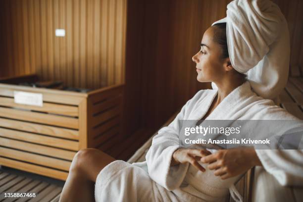 portrait of young attractive woman smiling and relaxing in sauna at spa. - beautiful woman spa stock pictures, royalty-free photos & images