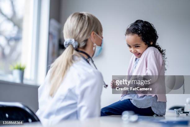 bambina che ridacchia ai medici - medical research foto e immagini stock