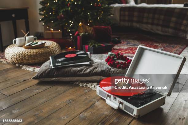 record player playing vinyl in christmas decorated apartment. - listening to music old stock pictures, royalty-free photos & images