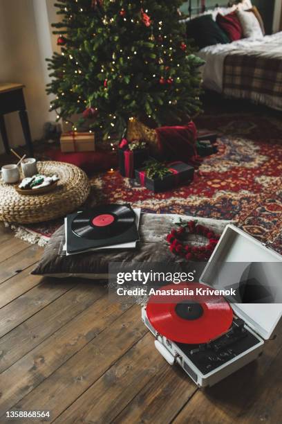 record player playing vinyl in christmas decorated apartment. - christmas photo album stock pictures, royalty-free photos & images