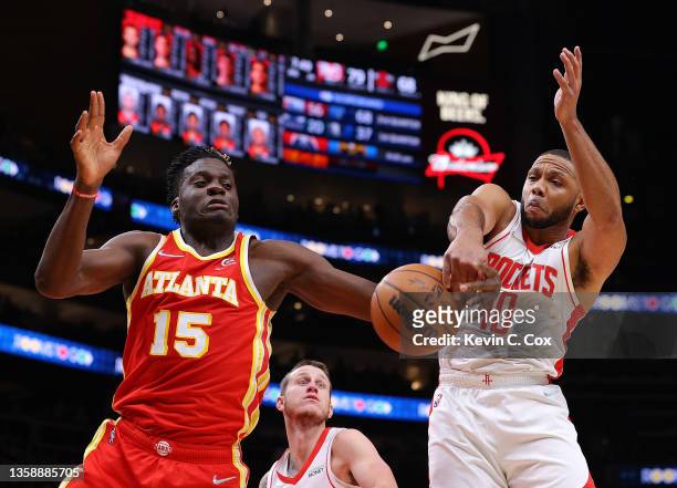 Clint Capela of the Atlanta Hawks and Eric Gordon of the Houston Rockets battle for a rebound during the second half at State Farm Arena on December...