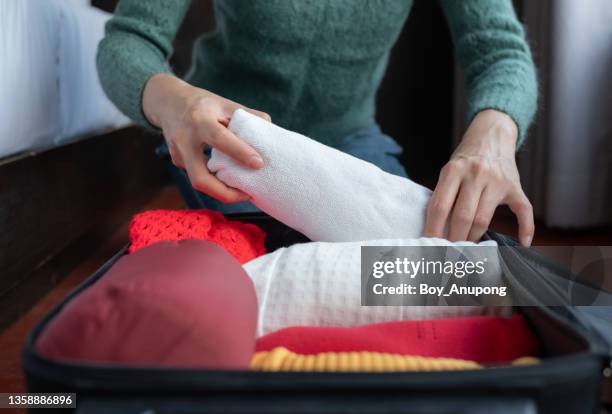 close up of woman hands open suitcase for pack and arranging cloths for travelling on her holiday. - sleeve roll stock pictures, royalty-free photos & images