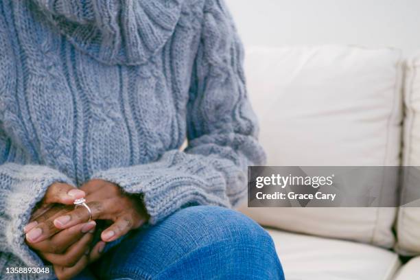 woman removes ring from finger - echtscheiding stockfoto's en -beelden