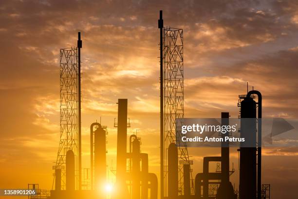 oil refinery plant of petroleum or petrochemical industry production at sunset - gas plant sunset stock-fotos und bilder