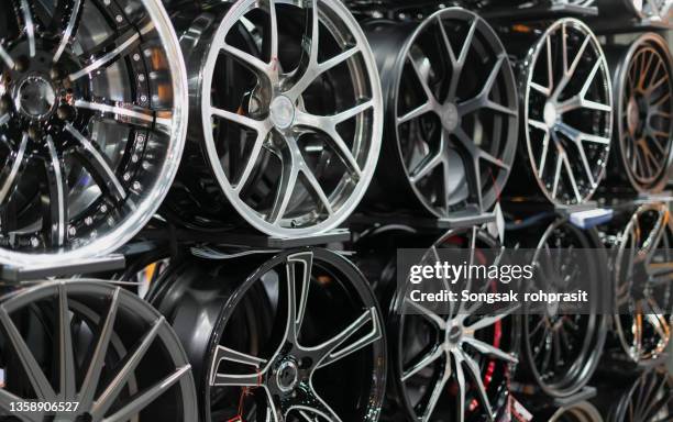 fancy rims on a big rack in a specialist store. - alloy stock pictures, royalty-free photos & images