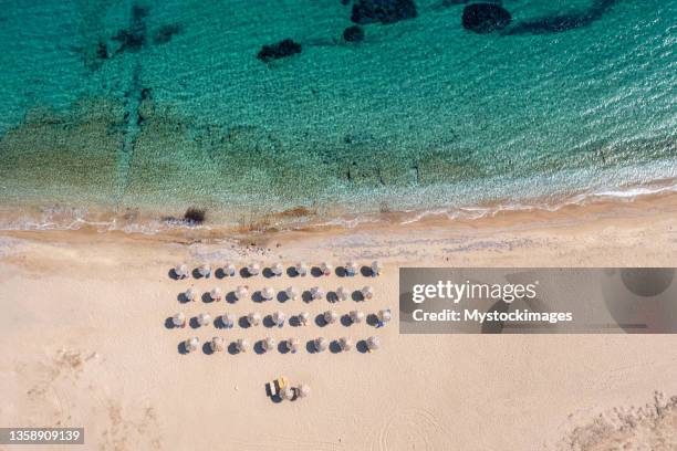 vue aérienne par drone de la plage avec parasols en grèce - ile d'ios grèce photos et images de collection