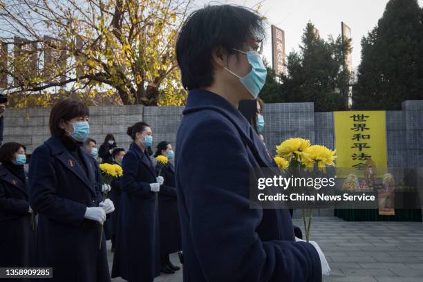 Monks and Buddhists from Linggu Temple and Usnisa Palace participate in a memorial ceremony for the victims in Nanjing Massacre in front of the...