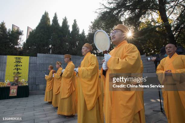 Monks and Buddhists from Linggu Temple and Usnisa Palace participate in a memorial ceremony for the victims in Nanjing Massacre in front of the...