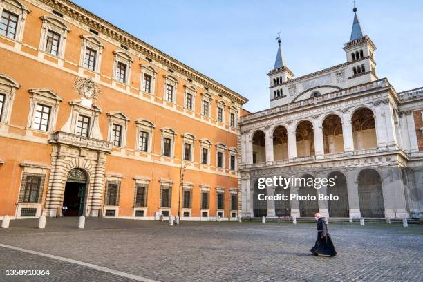 um padre atravessa a esplanada da basílica de san giovanni em laterano, no coração de roma - san giovanni in laterano - fotografias e filmes do acervo