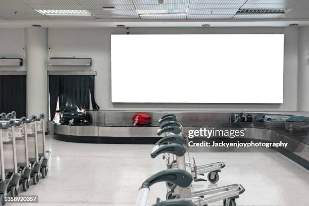 billboard at baggage claim in the airport - premiere of winterstone pictures deserted arrivals stockfoto's en -beelden