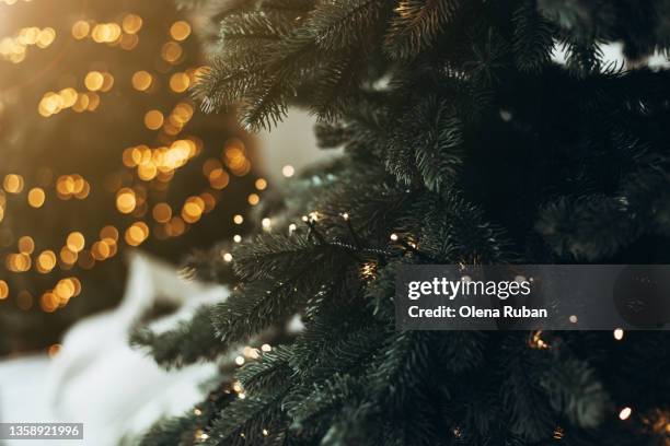 xmas trees with garlands and pile of snow between. - decorated christmas trees outside stockfoto's en -beelden