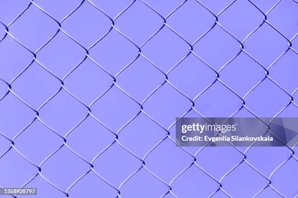 very peri chain link fence on yellow background. - chain fence stock pictures, royalty-free photos & images