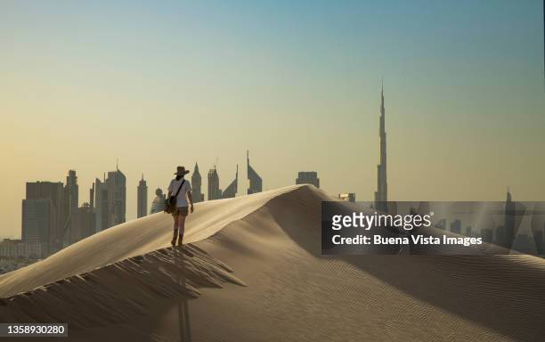 woman on a sand dune with futuristic city - hot arabian women stock pictures, royalty-free photos & images