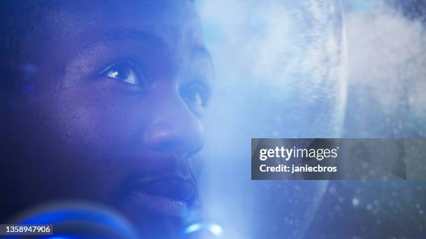 looking for new earth. african ethnicity man exploring space, travelling through bright cosmic dust - anticipation face stock pictures, royalty-free photos & images