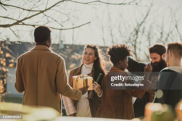 couple welcoming and greeting their friends who came to their home as guests - winter party stock pictures, royalty-free photos & images