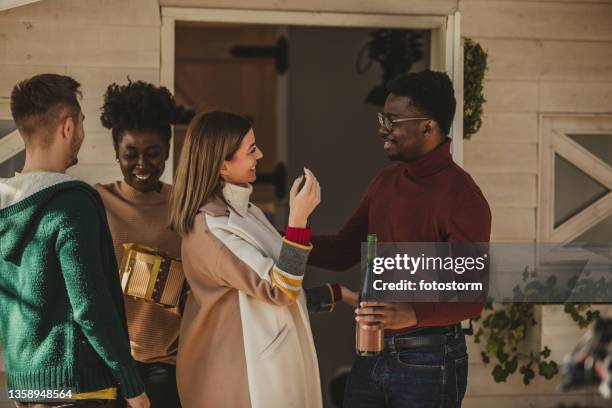 couple welcoming their friends in their home - wine gift stock pictures, royalty-free photos & images