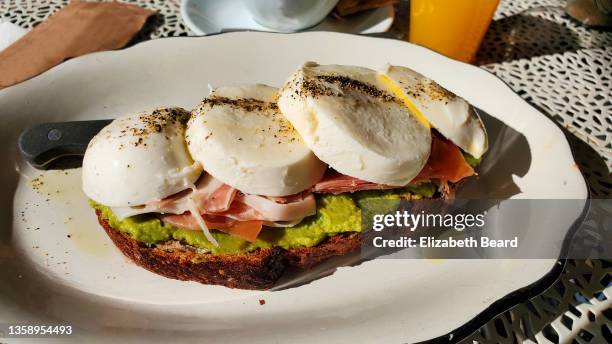 avocado toast with mozzarella and prosciutto - avocato oil stock-fotos und bilder