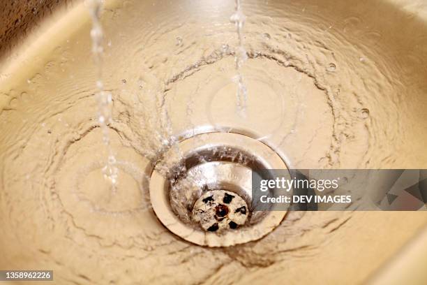 close up of stainless steel sink plug hole -concept of water saving - abfluss stock-fotos und bilder