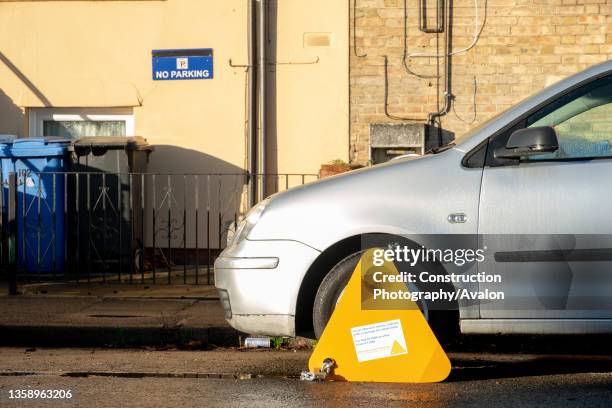 Car with a wheelclamp outside a property with a No Parking sign, 17th December 2020.