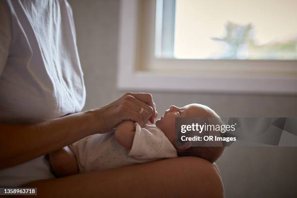 newborn baby lying on lap of mother - op schoot stockfoto's en -beelden