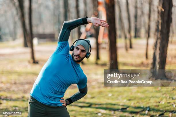 sporty man stretching exercise for warming up before running in the park or gym workout. fitness and healthy lifestyle concept. - individual event stock pictures, royalty-free photos & images