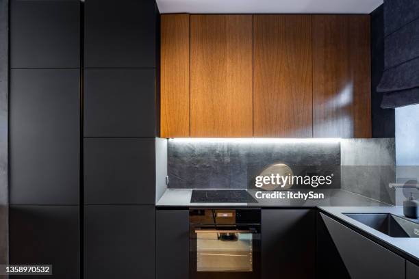 modern kitchen with black cabinet facades - dark kitchen stock pictures, royalty-free photos & images