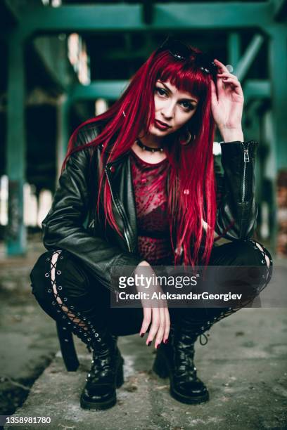 goth redhead female kneeling in abandoned building ruins - heavy metal stock pictures, royalty-free photos & images