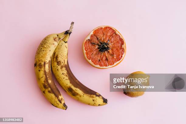 fruit with mold on a pink background - food borne illness stock pictures, royalty-free photos & images
