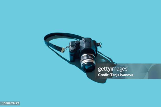 camera on blue background - digitalkamera stock-fotos und bilder