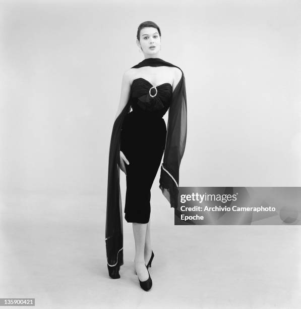 Model wearing a full-length evening dress by Biki, Milan, 16th February 1956.